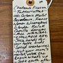 Handwritten wine label on a wooden surface