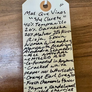Handwritten tag with product details on a wooden surface