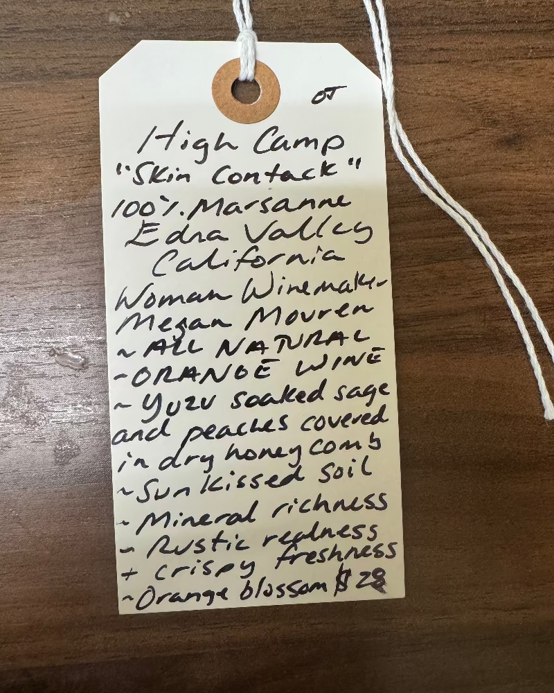 Handwritten wine label on a wooden surface