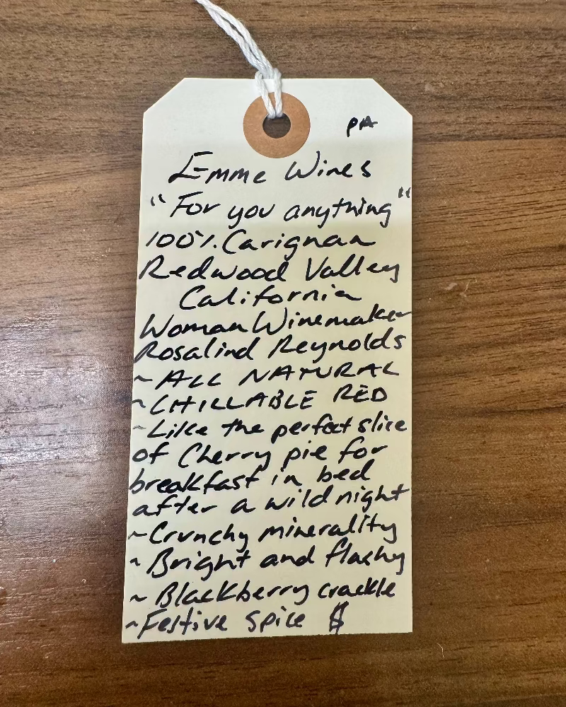 Handwritten wine label on a wooden surface