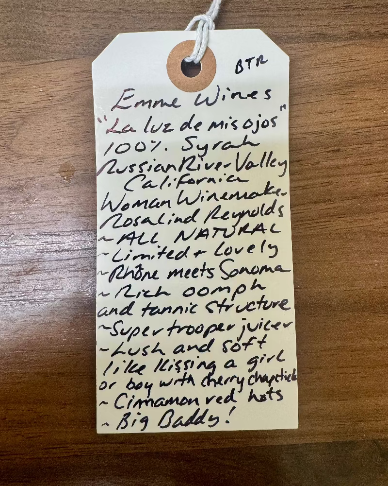 Handwritten wine label on a wooden surface