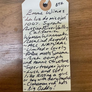 Handwritten wine label on a wooden surface