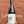 Wine bottle held in front of a textured red brick wall