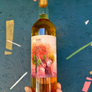 Bottle of wine held in front of a colorful, abstract background