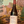 Bottle of Morgon wine held in front of a painted mural with animals and landscapes.