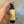 Hand holding a bottle of olive oil with a yellow label on a reflective surface.