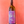 Wine bottle with purple label featuring a bicycle design, held against a red background.