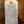 Handwritten tag on a wooden surface with text about a wine product.