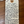 Handwritten tag on a wooden surface with product details.