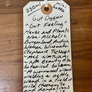Handwritten label on a wooden surface with product details.
