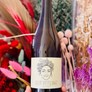 Bottle of 'Gut Feeling' beer held in front of decorative plants