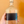 Hand holding a bottle labeled 'yuzu' against an orange background
