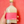 Bottle of 'cloudy sake' with a pink label held against a red background