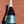 Bottle of Prosecco DOC with a blue label held against a textured brown background