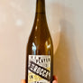 Bottle of New Player Rio Rocca with a label held by a hand against a neutral background