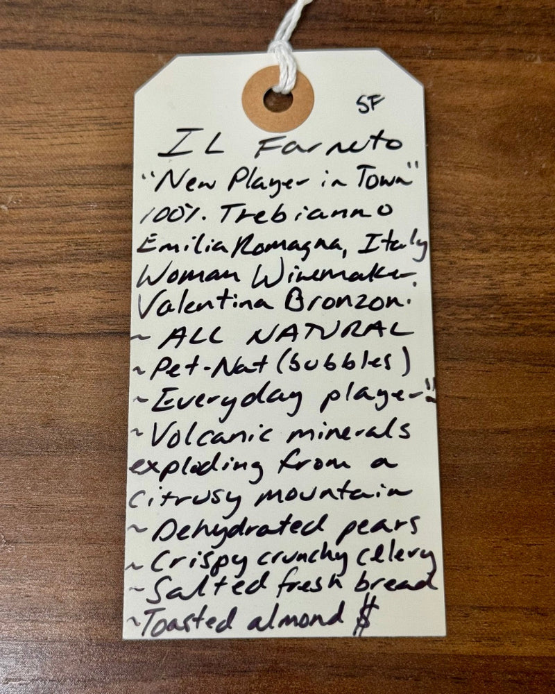 Handwritten tag on a wooden surface with product description