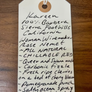 Handwritten tag with wine description on a wooden surface