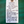 White tag with handwritten text on a green background
