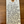 Handwritten tag on a wooden surface with product details.