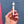 A hand holding a small white cylindrical object with a blue band and a white tip, set against a textured blue wall with a pink stripe at the bottom.
