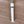 A small white cylindrical object with a blue band near one end, placed on a brown wooden surface.