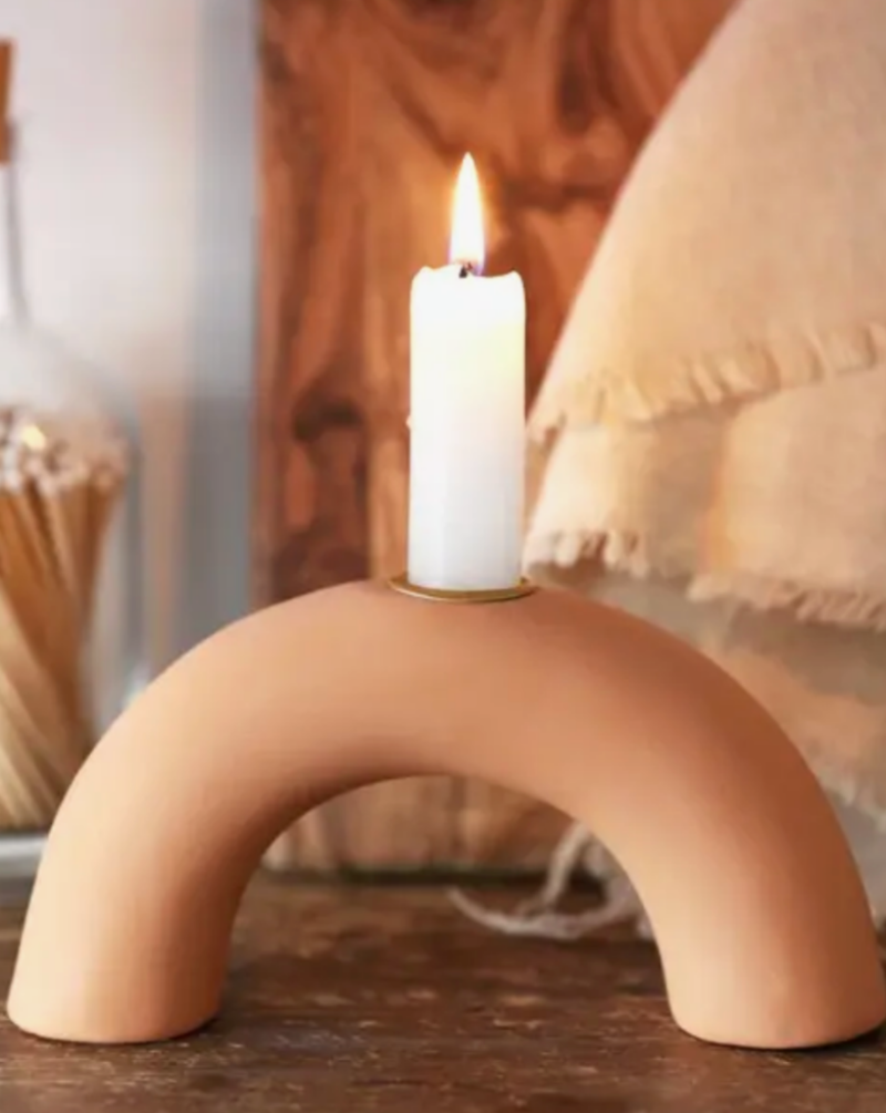 Bring a warm glow to your home with this modern candlestick holder. Made from smooth terracotta in an arch shape, and featuring a gold hole in the top for a tall candlestick. Perfect for placing in the middle of the dining table or on a mantelpiece, this home accessory is a beautiful piece to create an on-trend interior look.