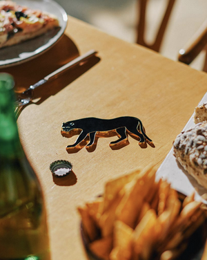 Fashionable enameled metal bottle opener shaped as a panther.