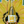 A hand holding a bottle of Late Bloomer sparkling wine with a vibrant yellow background featuring sunflower designs.