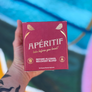 Box of Aperitif before alcohol recovery blend held by a person with a tattooed hand.