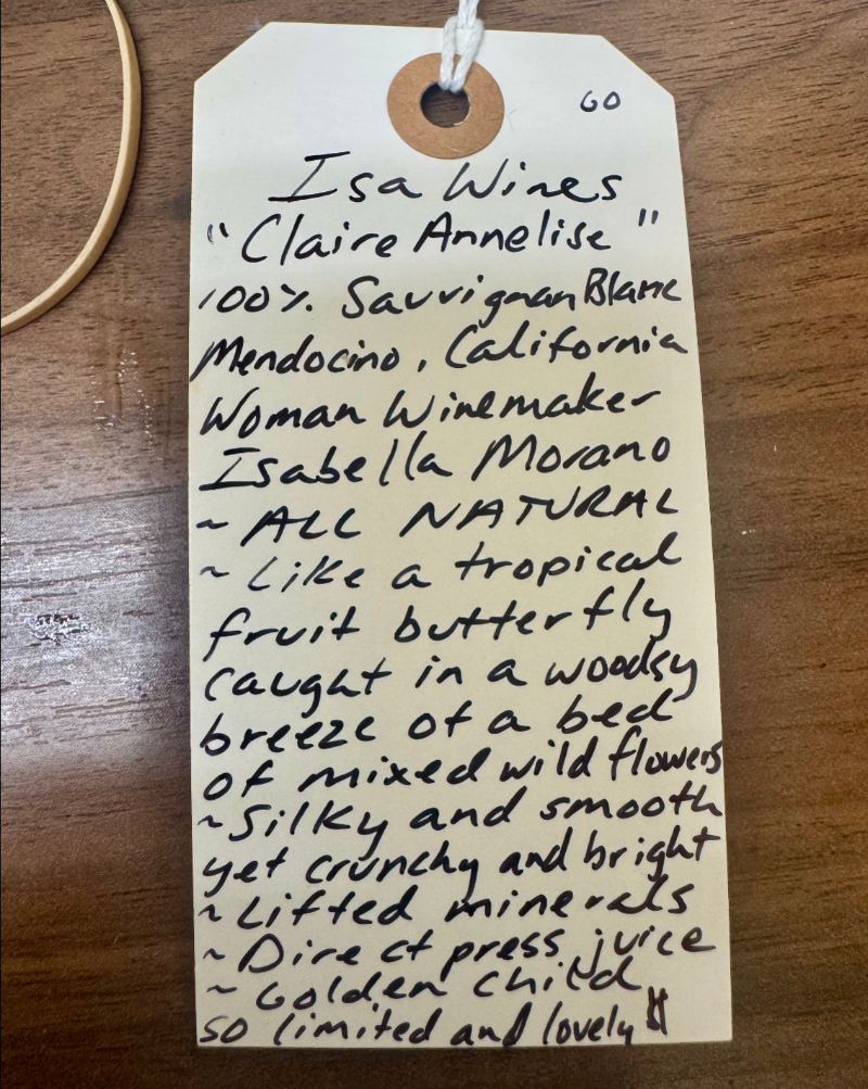 Handwritten wine label on a wooden surface