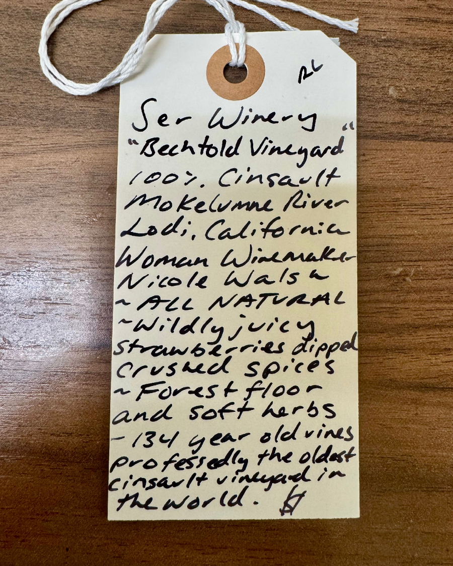Handwritten wine label on a wooden surface
