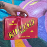 Red Calimocho 12 pack box held in front of a colorful background