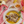Plate of fish in a yellow sauce with a fork on a pink tablecloth.