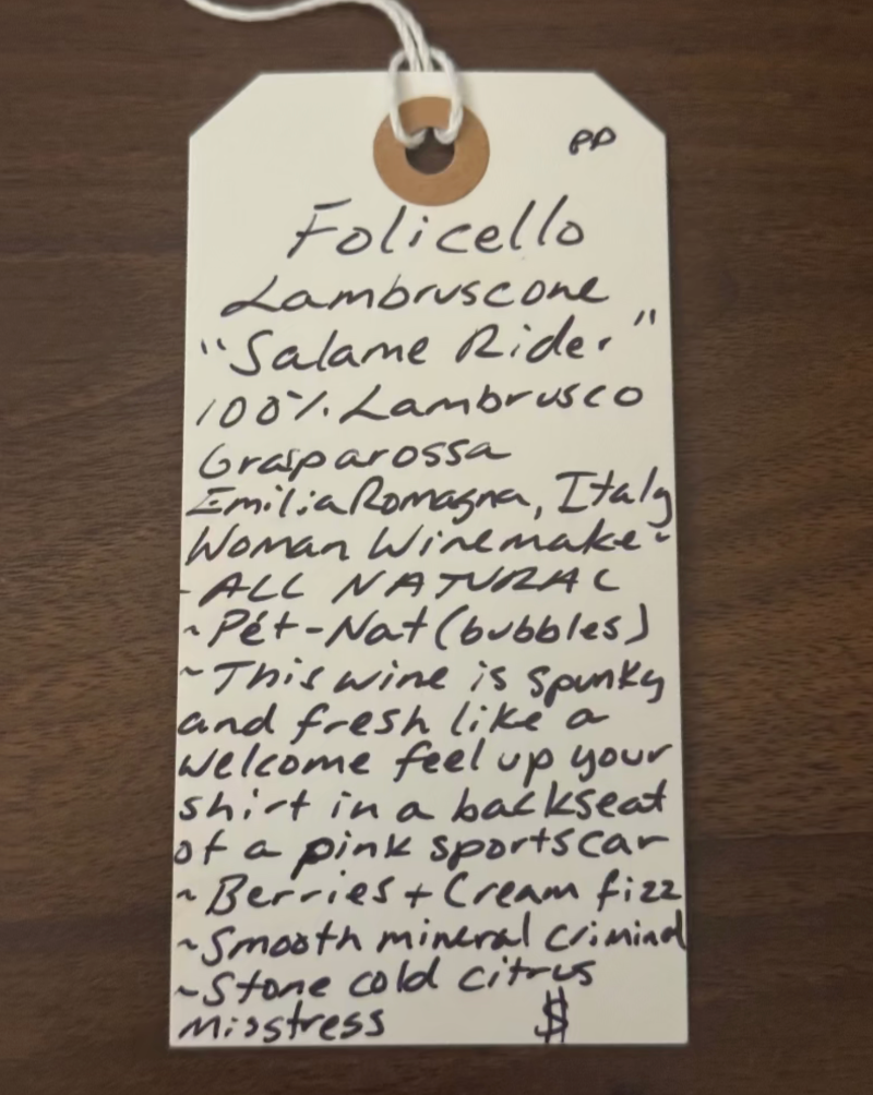 Handwritten wine label on a wooden surface