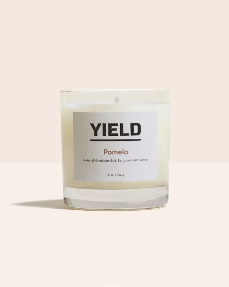 Yield Pomelo candle on a light beige background