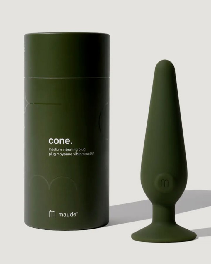 Green medium vibrating plug with packaging on a light gray background