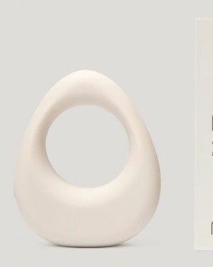 White 'band.' vibrating ring by Maude with packaging on a light gray background