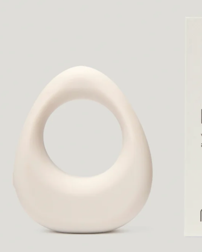 White 'band.' vibrating ring by Maude with packaging on a light gray background
