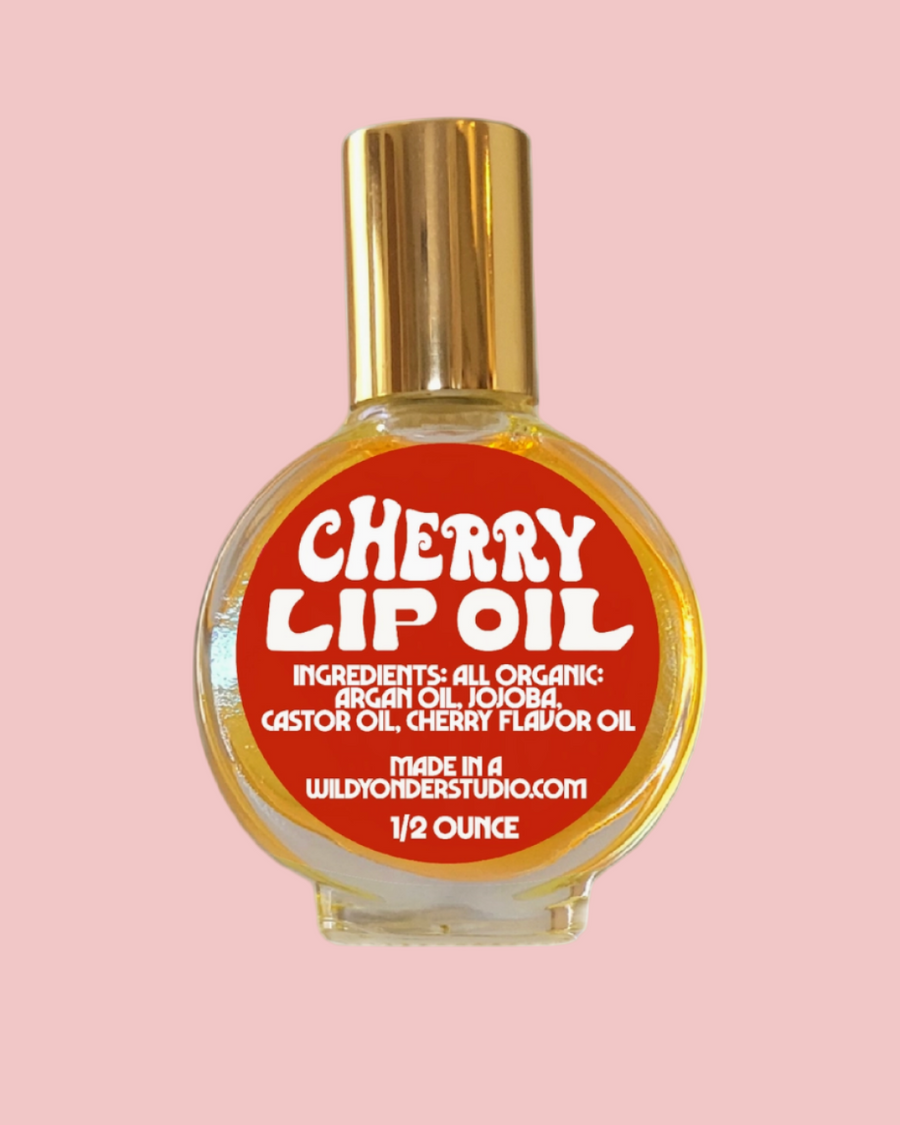 Bottle of cherry lip oil with a red label on a white background