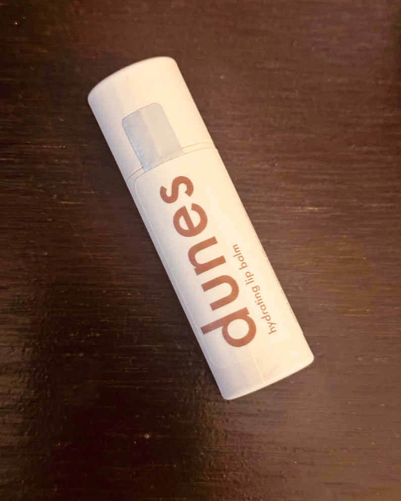 White cylindrical container with 'puns' branding on a dark wooden surface