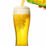Beer being poured into a glass with a brand label in the background