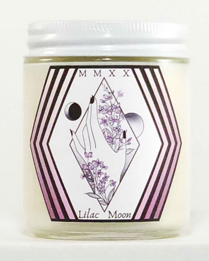 Candle jar with 'Lilac Moon' label featuring geometric design and floral elements on a white background.