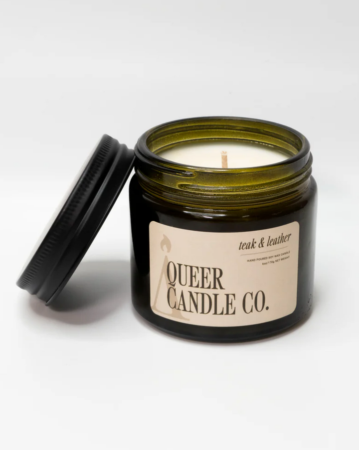 Candle in a jar with 'Queer Candle Co.' label on a white background