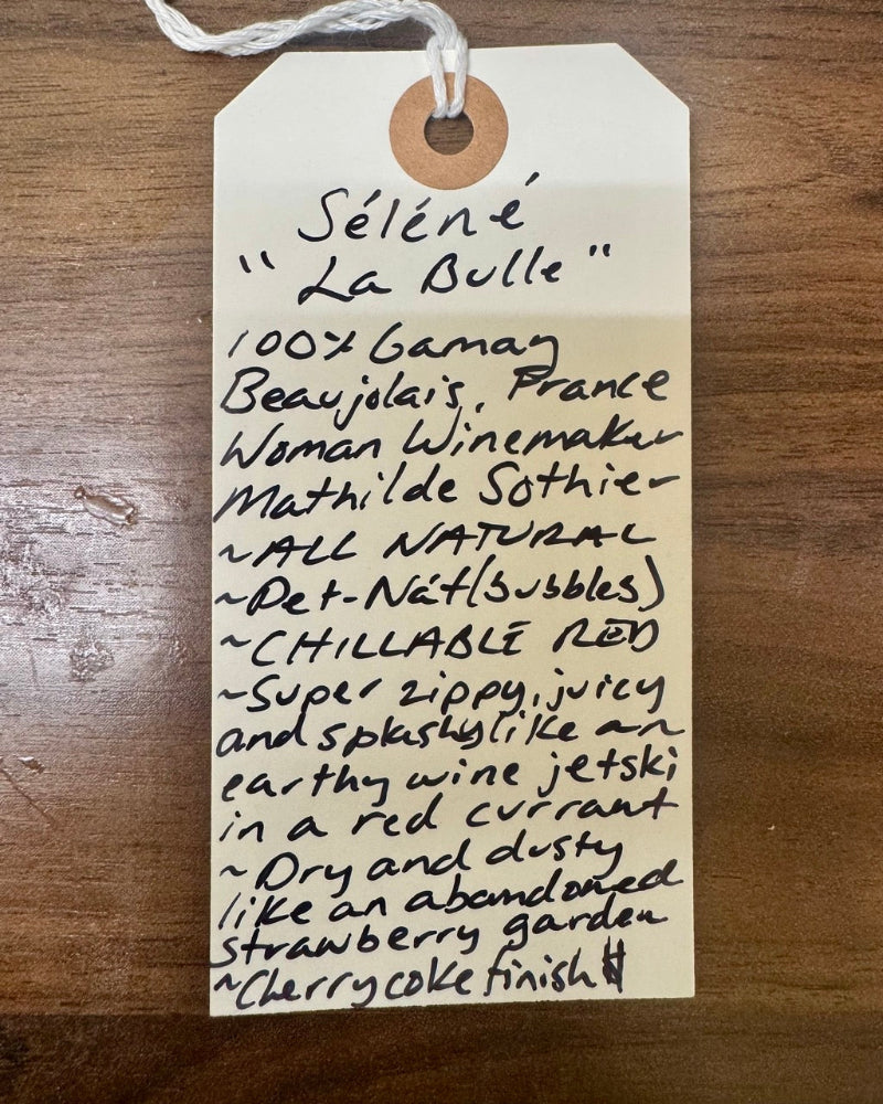 Handwritten tag on a wooden surface with product details.