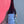 Hand holding a bottle labeled 'SKOG 03' against a pink and gray background