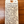 A handwritten cream-colored paper tag with a wooden tab at the top, reading 'Vitteau-Albert' and describing a Chardonnay and Aligotte Burgundy wine blend, photographed on a dark wood surface.